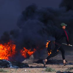 Un manifestante palestino quema neumáticos durante enfrentamientos con soldados israelíes al este de Rafah, en el sur de la Franja de Gaza, cerca de la valla fronteriza entre Israel y Gaza. | Foto:SAID KHATIB / AFP