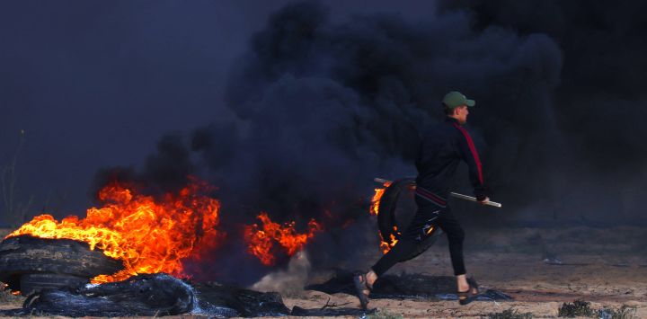 Un manifestante palestino quema neumáticos durante enfrentamientos con soldados israelíes al este de Rafah, en el sur de la Franja de Gaza, cerca de la valla fronteriza entre Israel y Gaza.