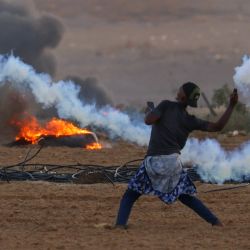 Un manifestante palestino devuelve un bote de gas lacrimógeno durante enfrentamientos con soldados israelíes al este de Rafah, en el sur de la Franja de Gaza, cerca de la valla fronteriza entre Israel y Gaza. | Foto:SAID KHATIB / AFP