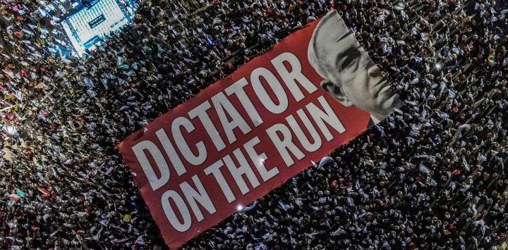 Esta vista aérea muestra a los manifestantes desplegando una pancarta gigante contra el primer ministro israelí, Benjamin Netanyahu, durante una manifestación contra el plan de reforma judicial del gobierno israelí cerca del centro comercial Azrieli en Tel Aviv.