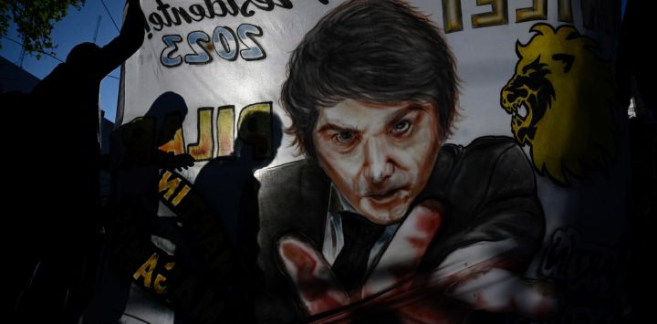 Las siluetas de los partidarios del congresista argentino y candidato presidencial de la Alianza Avanza La Libertad, Javier Milei, se ven en un cartel con su imagen pintada durante un mitin de campaña en San Martín, provincia de Buenos Aires.