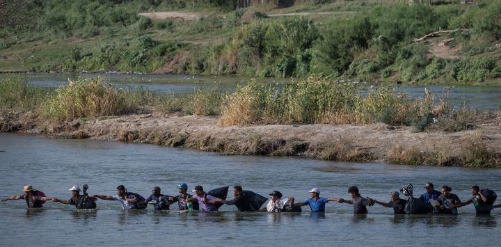 Un grupo de migrantes cruza el río Grande hacia Eagle Pass, Texas. Docenas de migrantes llegaron a la frontera entre Estados Unidos y México con la esperanza de que se les permitiera ingresar a los Estados Unidos.