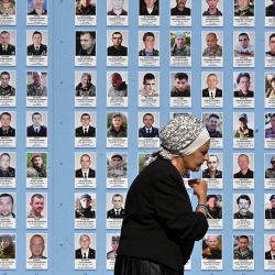 Una mujer pasa junto al Muro de la Memoria de los Defensores Caídos de Ucrania en la Guerra Ruso-Ucraniana en Kiev. | Foto:SERGEI SUPINSKY / AFP