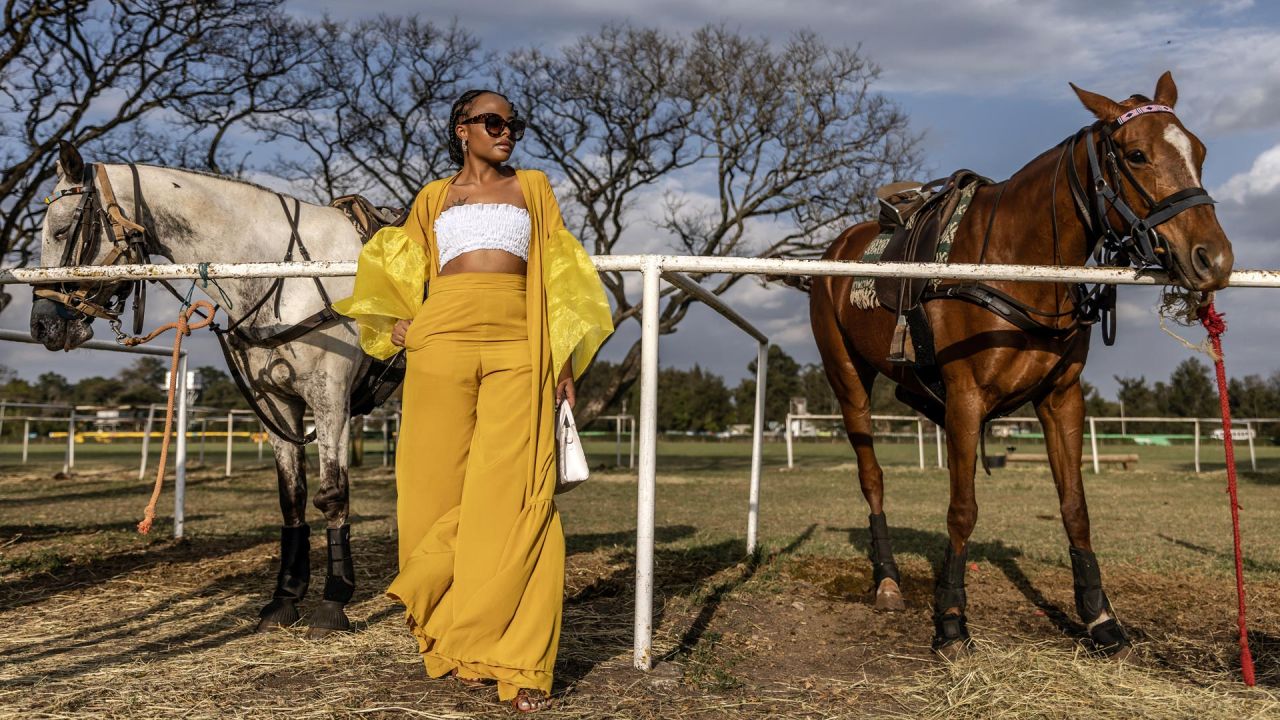 Una aficionada al polo sigue un partido junto a algunos caballos durante la Copa Casino en el Nairobi Polo Club de Nairobi, Kenia. Fundado en 1907, Nairobi Polo Club es el club de polo más antiguo de África Oriental y alberga varios torneos destacados cada año. . El polo está ganando gran popularidad en Nairobi a medida que más kenianos se interesan en la cultura del polo y el estilo de vida que la rodea. | Foto:LUIS TATO/AFP