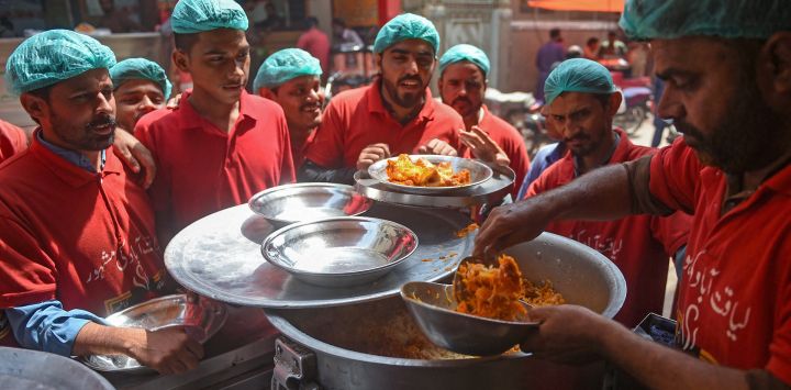 En esta fotografía un personal sirve platos de biryani en un restaurante de Karachi. Mirándose unos a otros a través de una corriente de tráfico, los locales rivales de biryani paquistaníes compiten por los clientes, sirviendo una ardiente mezcla de carne, arroz y especias que une y divide los apetitos del sur de Asia.