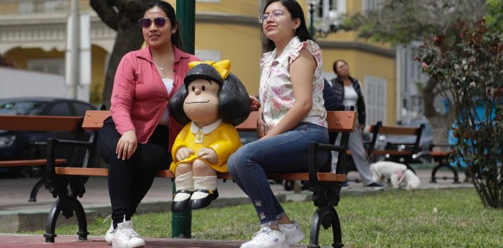 Mujeres posan para una fotografía con una escultura de Mafalda, en el distrito de Barranco, en Lima, Perú. Tanto peruanos como visitantes extranjeros observan con mucho interés y emoción la nueva escultura del personaje de historieta Mafalda, que se convirtió en la octava de su tipo instalada en el mundo, con un lugar en el distrito de Barranco, en el sur de la ciudad de Lima.