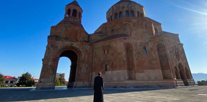 Un sacerdote se encuentra frente a una iglesia en Stepanakert, Artsaj.
