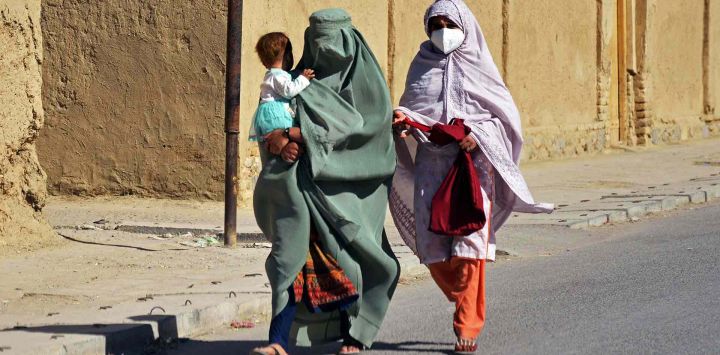 Mujeres afganas junto con un niño caminan por una calle en las afueras de la provincia de Kandahar. Foto de Sanaullah SEIAM / AFP
