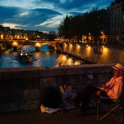 Un artista vende sus cuadros por la noche en el puente Petit Pont Petit Pont de París. Foto de Dimitar DILKOFF / AFP | Foto:AFP