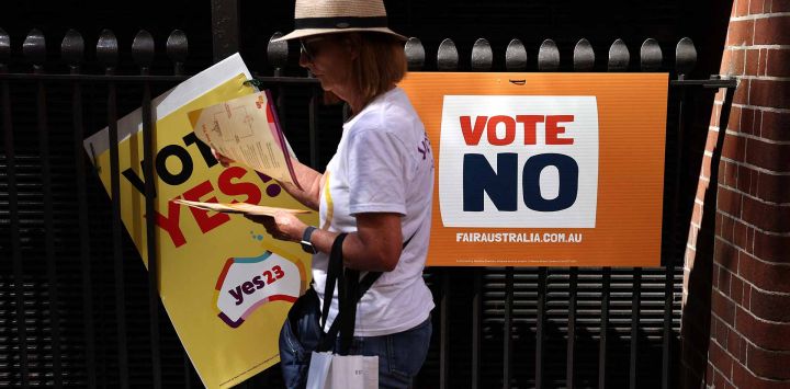 Un voluntario reparte folletos electorales frente a un centro de votación en el centro de Sydney. Foto de DAVID GRAY / AFP