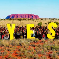 Los representantes de base electos de comunidades remotas en Australia Central posando frente al emblemático Uluru, también conocido como Ayers Rock, "sí" a una voz en el Parlamento. Foto de Tina Tilhard / AFP | Foto:AFP