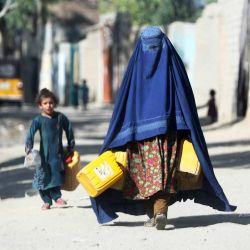 Una mujer afgana vestida con burka lleva botes para ir a buscar agua potable en Jalalabad. Foto de Shafiullah KAKAR / AFP | Foto:AFP