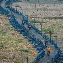 La gente pasa por un puente flotante que cruza unos 300 metros sobre el río seco Citarum en Cihampelas, Java Occidental. Foto de Timur MATAHARI / AFP | Foto:AFP