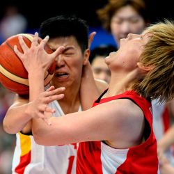 La japonesa Maki Takada (R) y la china Huang Sijing compiten por el balón en el último partido de baloncesto femenino entre Japón y China. Foto de Philip FONG / AFP | Foto:AFP