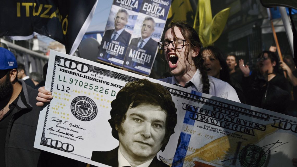 Tiago Codevilla holds a giant 100-dollar bill with the face of Argentine congressman and presidential candidate for the La Libertad Avanza Alliance, during a campaign rally in San Martín, Buenos Aires Province, on September 25, 2023. 