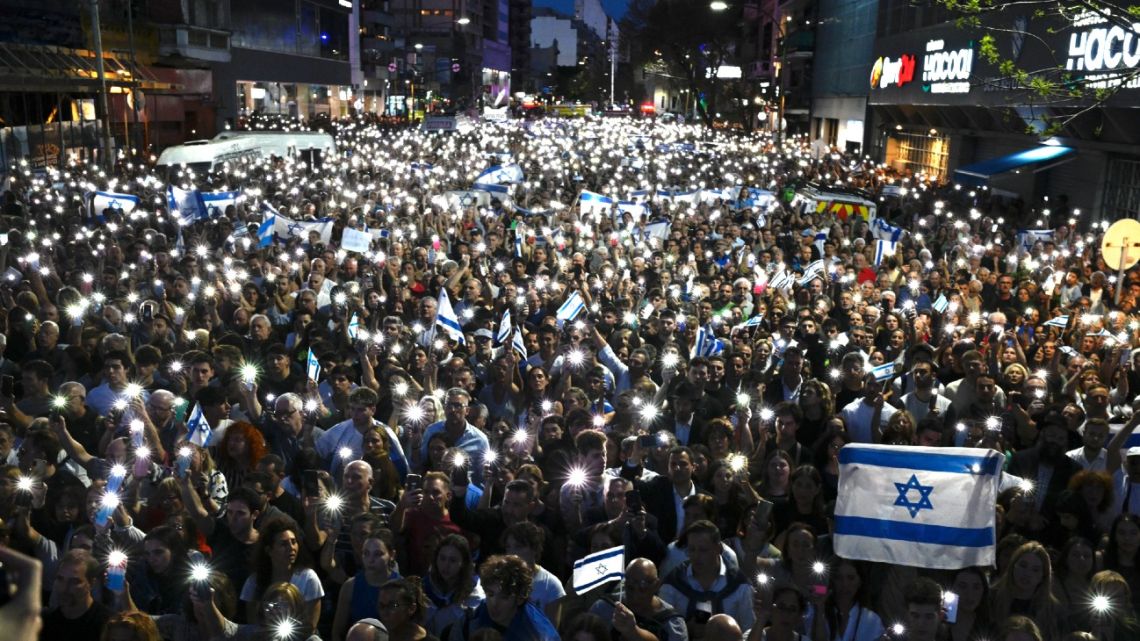 People hold Israeli national flags and display their lit mobile phones during a rally in support of the people of Israel, in Buenos Aires on October 9, 2023, following the October 7 shock deadly attack on Israel by Palestinian militant group Hamas. 