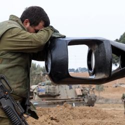 Un soldado israelí apoya su cabeza sobre el cañón de un arma de artillería de un vehículo blindado mientras los soldados israelíes toman posiciones cerca de la frontera con Gaza en el sur de Israel. Aturdido por el asalto sin precedentes a su territorio, un Israel afligido ha contado más de 700 muertos y lanzó una andanada fulminante de ataques contra Gaza que han elevado el número de muertos allí a 493, según funcionarios palestinos. | Foto:JACK GUEZ / AFP