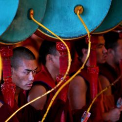 Los monjes budistas tocan la batería durante las oraciones matutinas en el monasterio de Gyuto en Dharamsala. | Foto:ARUN SANKAR / AFP