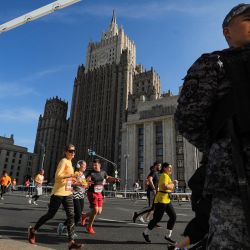 Un agente de la ley observa cómo los corredores participan en el maratón anual de Moscú en el centro de Moscú. | Foto:Handout / Moskva News Agency / AFP
