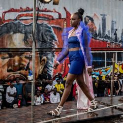 Los modelos caminan por la pasarela mientras exhiben diseños en el desfile de moda principal durante la Semana de la Moda de Kibera en el asentamiento informal de Kibera en Nairobi, Kenia. | Foto:LUIS TATO/AFP