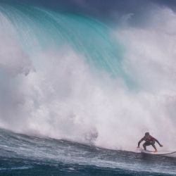 El surfista hawaiano Steve Roberson monta una ola mientras un gran oleaje llega a la zona de surf conocida como Jaws, en la costa norte de la isla de Maui, Hawái. | Foto:Brian Bielmann / AFP
