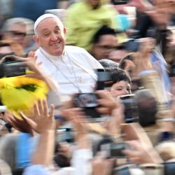 El Papa Francisco saluda a la multitud cuando llega a la audiencia general semanal en la plaza de San Pedro en el Vaticano. | Foto:ALBERTO PIZZOLI / AFP