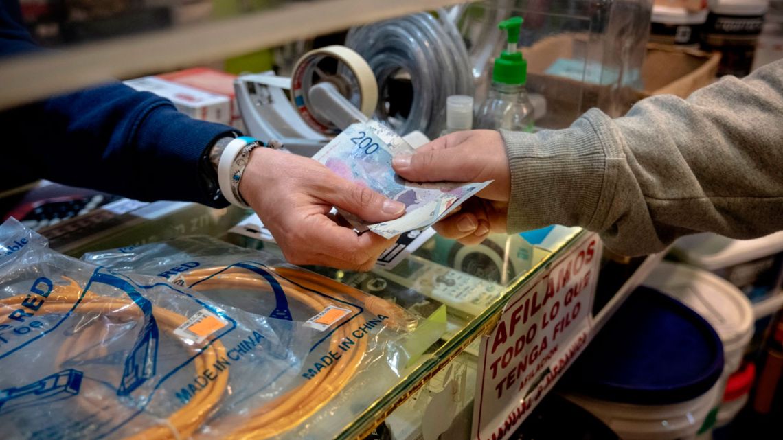 A customer pays in pesos at a shop in Buenos Aires, Argentina last month. Fears of another devaluation are running high as the October 22 election nears.