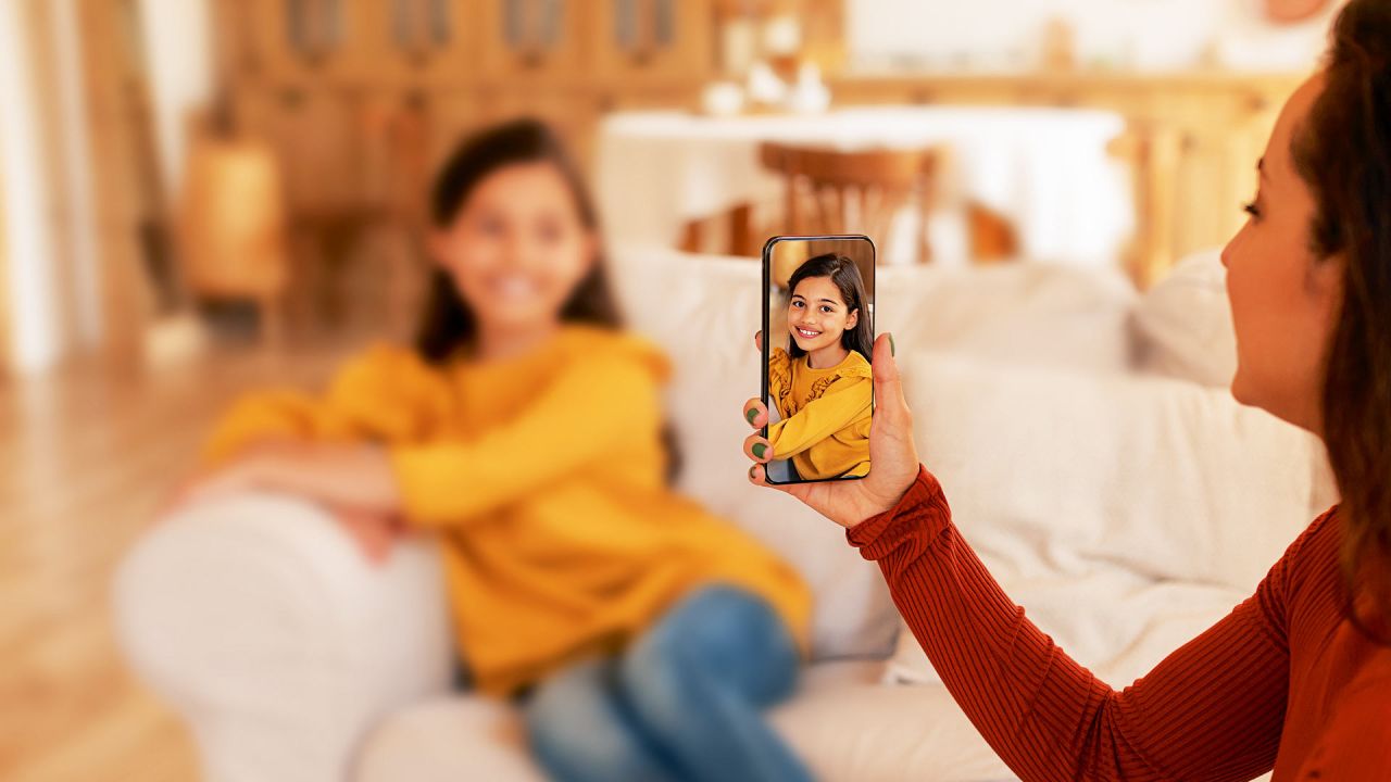 Una mamá que fotografía a su hija para subir la imagen a las redes. | Foto:Shutterstock