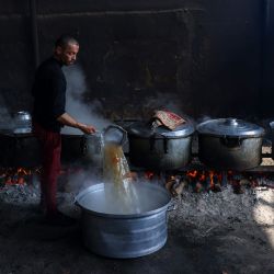 Los palestinos preparan comidas para el refugio de la ONU que se distribuirán entre los desplazados en Rafah, en el sur de la Franja de Gaza, en medio de las batallas en curso entre Israel y los militantes de Hamás. | Foto:MOHAMMED ABED / AFP