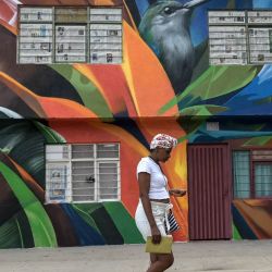 Una mujer pasa junto a un mural en Cali, Colombia. | Foto:JOAQUIN SARMIENTO / AFP