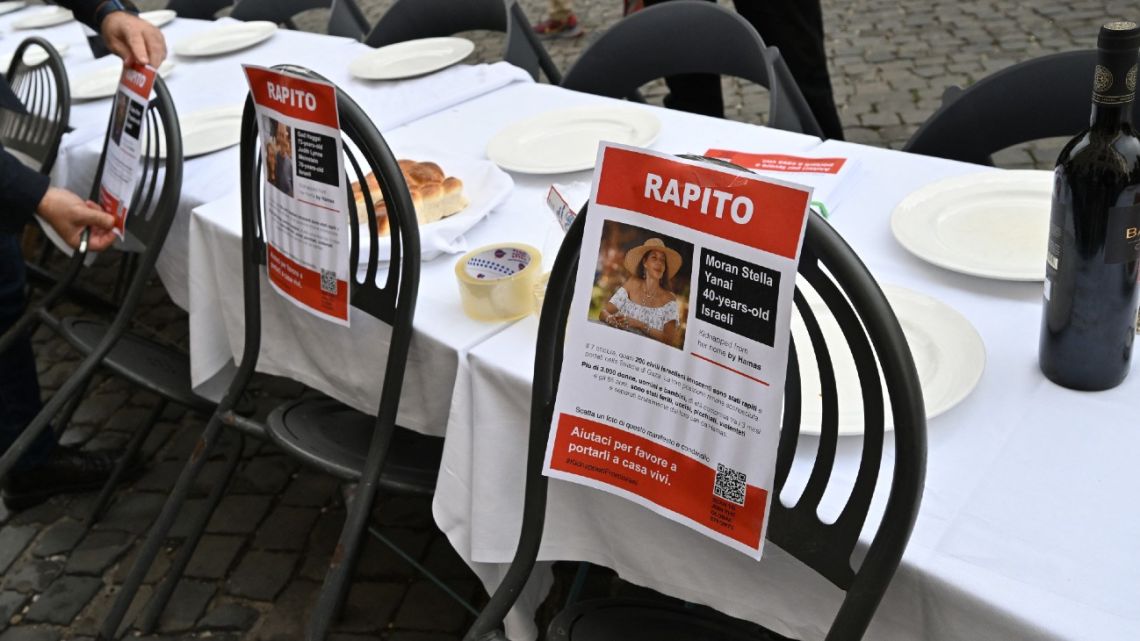 Members of the Jewish community set a giant table for 203 guests in support of the Israeli hostages in Gaza, on October 20, 2023 in front of the Synagogue of Rome's former jewish ghetto neighborhood. Each poster shows a portrait with the name and the age of the hostage under the word 'kidnapped' in Italian. On October 7, the Palestinian militant group carried out a deadly assault on Israel, the worst in the country's 75-year history, killing more than 1,400 people, mostly civilians who were shot, mutilated or burnt to death on the first day of the raid, according to Israeli officials. Israel has responded with a relentless bombardment that has killed at least 3,785 people in the Gaza Strip, mostly civilians, according to the Hamas-run health ministry in the territory.  