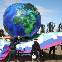 Activistas medioambientales se encuentran junto a un globo inflable mientras se reúnen para participar en una manifestación contra el proyecto de la autopista A69 entre Toulouse y Castres, en Saix, suroeste de Francia. | Foto:CHARLY TRIBALLEAU / AFP