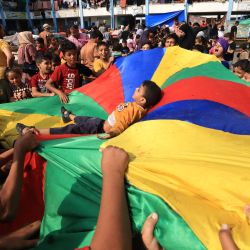Niños palestinos que han huido de sus hogares debido a los ataques israelíes juegan con la ayuda de juegos organizados por trabajadores humanitarios mientras se refugian en una escuela administrada por las Naciones Unidas, en Khan Yunis, en el sur de la Franja de Gaza. | Foto:MAHMUD JAMONES / AFP