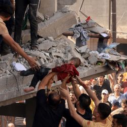 Rescatistas sacan a un niño de los escombros de un edificio alcanzado por un ataque aéreo israelí en Khan Yunis, en el sur de la Franja de Gaza. Miles de civiles, tanto palestinos como israelíes, han muerto desde octubre 7 de octubre de 2023, después de que militantes palestinos de Hamás con base en la Franja de Gaza ingresaran al sur de Israel en un ataque sin precedentes que desencadenó una guerra declarada por Israel a Hamás con bombardeos de represalia en Gaza. | Foto:MAHMUD HAMS / AFP