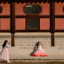 Una mujer con un vestido tradicional Hanbok posa para una fotografía en los terrenos del Palacio Gyeongbokgung, en Seúl. | Foto:ANTHONY WALLACE / AFP