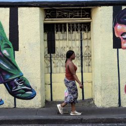 Una mujer pasa junto a un mural en Cali, Colombia. | Foto:JOAQUIN SARMIENTO / AFP