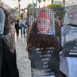 Personas con carteles con los rostros de rehenes israelíes retenidos por militantes palestinos desde el ataque del 7 de octubre protestan por su liberación frente a la embajada alemana en Tel Aviv. | Foto:AHMAD GHARABLI / AFP