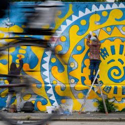 Las artistas ucranianas Anna Movenko y Julia Batsaliuk trabajan en un mural llamado "Ukrainian Sun" en la calle Margaretenguertel en Viena, Austria. | Foto:JOE KLAMAR / AFP