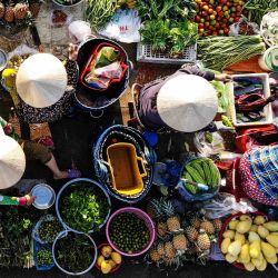 Esta fotografía aérea muestra a vendedores vendiendo verduras en el mercado de Vi Thanh en la provincia de Hau Giang, Vietnam. | Foto:NHAC NGUYEN / AFP