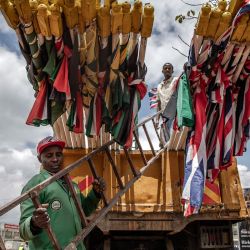 Los trabajadores del condado de la ciudad de Nairobi se preparan para descargar un camión con banderas de Kenia y el Reino Unido mientras las instalan en las calles antes de la visita del monarca británico a Kenia en Nairobi. | Foto:LUIS TATO/AFP