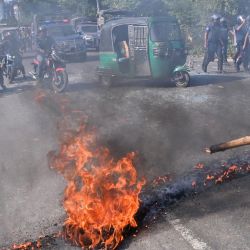 Los automovilistas observan cómo activistas del Partido Nacionalista de Bangladesh (BNP) prendieron fuego a una carretera mientras intentaban bloquear una autopista durante enfrentamientos con la policía en Araihazar, a unos 40 km de Dhaka. | Foto:MUNIR UZ ZAMAN / AFP