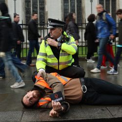Un activista climático de Just Stop Oil es detenido por un oficial de policía después de participar en una marcha para interrumpir el tráfico en la Plaza del Parlamento en Londres, mientras el grupo de protesta comienza otra serie de manifestaciones en toda la capital. | Foto:DANIEL LEAL / AFP