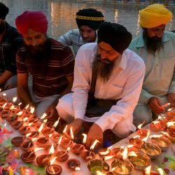 Devotos sij encienden velas en el Templo Dorado iluminado en el aniversario del nacimiento de Sikh Guru Ram Das, en Amritsar, India. | Foto:Narinder Nanu / AFP