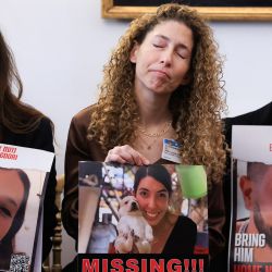 Familiares y conocidos sostienen fotografías de personas desaparecidas o rehenes, Noam Avigdori, Tamar y Elia Toldano, durante una reunión con un colectivo de familias de rehenes y personas desaparecidas de Hamas en la Asamblea Nacional francesa, en París. | Foto:EMMANUEL DUNAND / AFP