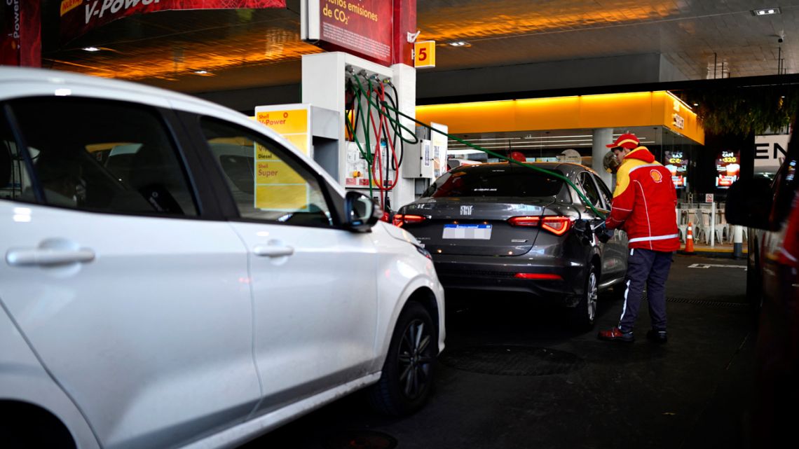 A worker at a petrol station fills a tank with petrol in Buenos Aires, on October 30, 2023. 