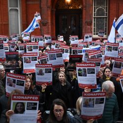 La gente sostiene carteles de los desaparecidos mientras se reúnen frente a la embajada de Qatar en Londres, para exigir la liberación de los 230 rehenes estimados en Gaza por Hamas después de los ataques dentro de Israel el 7 de octubre. | Foto:JUSTIN TALLIS / AFP