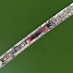 Esta fotografía aérea  muestra a turistas que viajan a bordo del popular "tren flotante" tomando fotografías a lo largo de las vías del tren durante una parada en medio de la presa Pasak Jolasid, el embalse más grande de Tailandia en la provincia de Lopburi. | Foto:MANAN VATSYAYANA / AFP