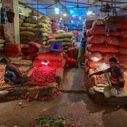 Los comerciantes esperan a los clientes en un mercado mayorista en Dhaka, Bangladesh. | Foto:MUNIR UZ ZAMAN / AFP