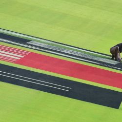 Un hombre pinta el césped en vísperas del partido internacional de la Copa Mundial de Críquet Masculino ICC 2023 entre Sudáfrica y Afganistán en el Estadio Narendra Modi en Ahmedabad. | Foto:SAM PANTHAKY / AFP