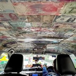 Un taxista conduce su taxi, decorado con diferentes billetes de moneda extranjera, en Bangkok, Tailandia. | Foto:MANAN VATSYAYANA / AFP